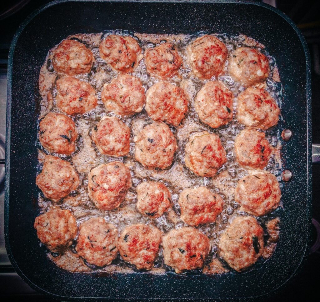 Meatballs browning in a skillet