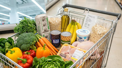 A grocery cart filled with affordable healthy foods,