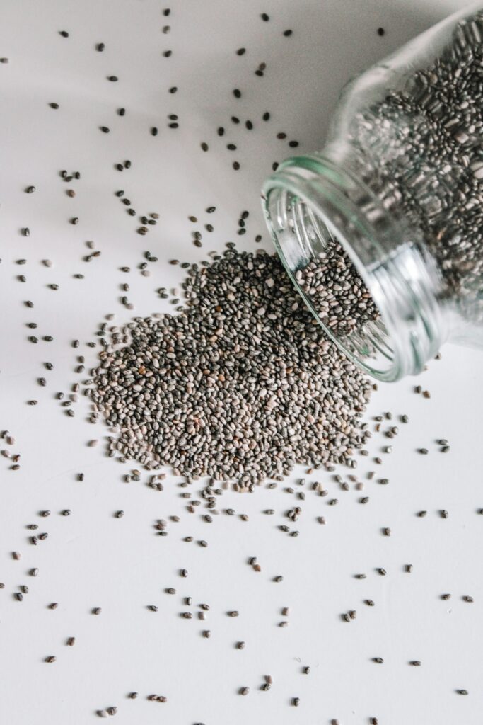 Chia seeds spilling from a glass jar