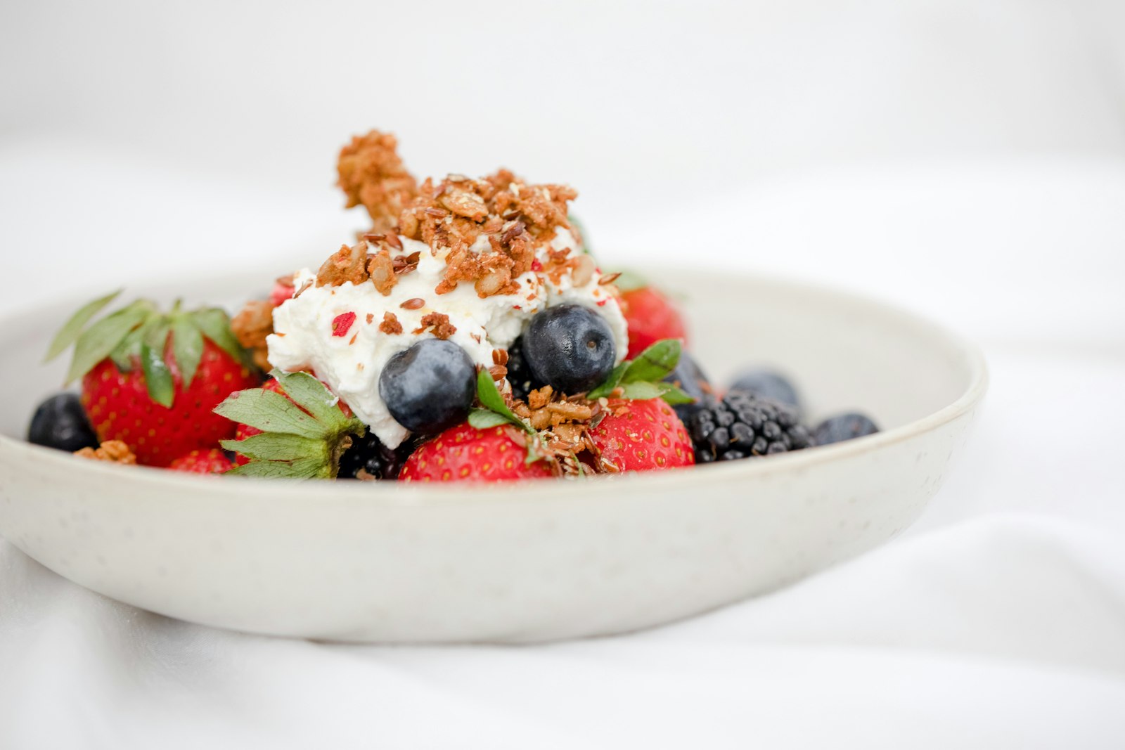 A creamy high-protein bowl topped with berries and granola