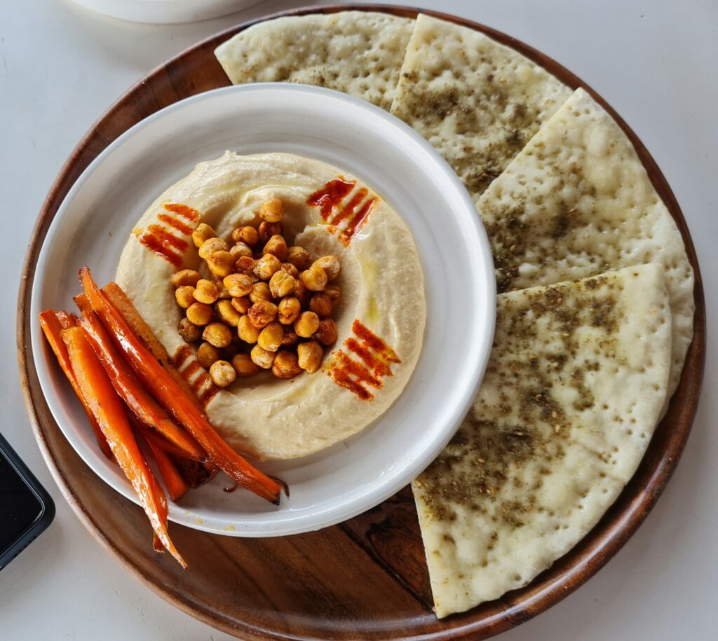 Hummus served with carrot sticks and pita