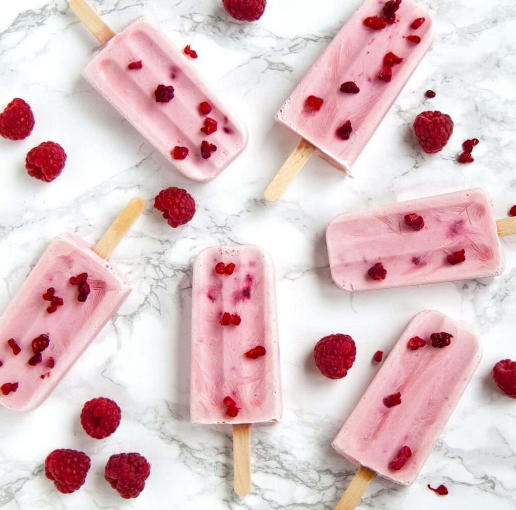 Pink raspberry cream popsicles with fresh raspberries