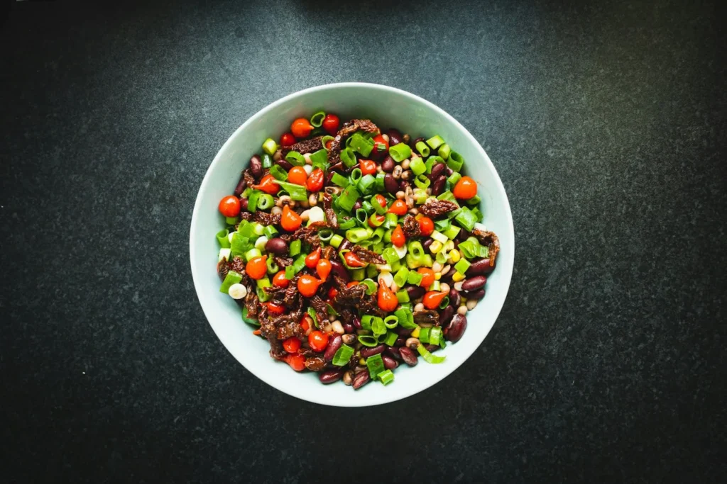 Bowl of kidney bean salad with cherry tomatoes and green onions