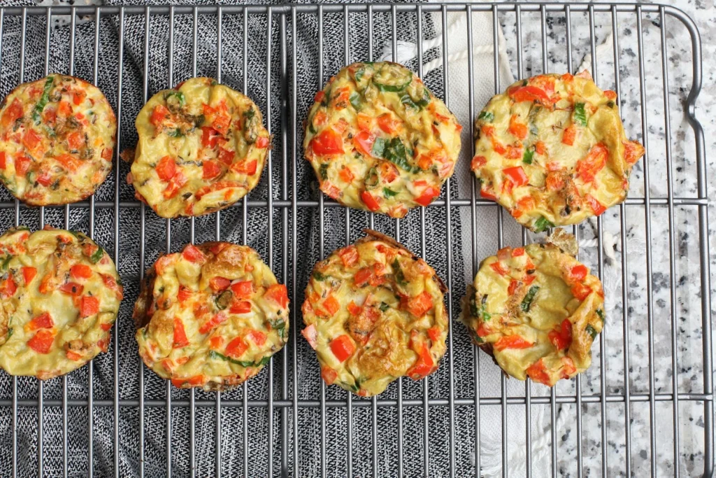 Egg muffins with red bell pepper and spinach cooling on a wire rack